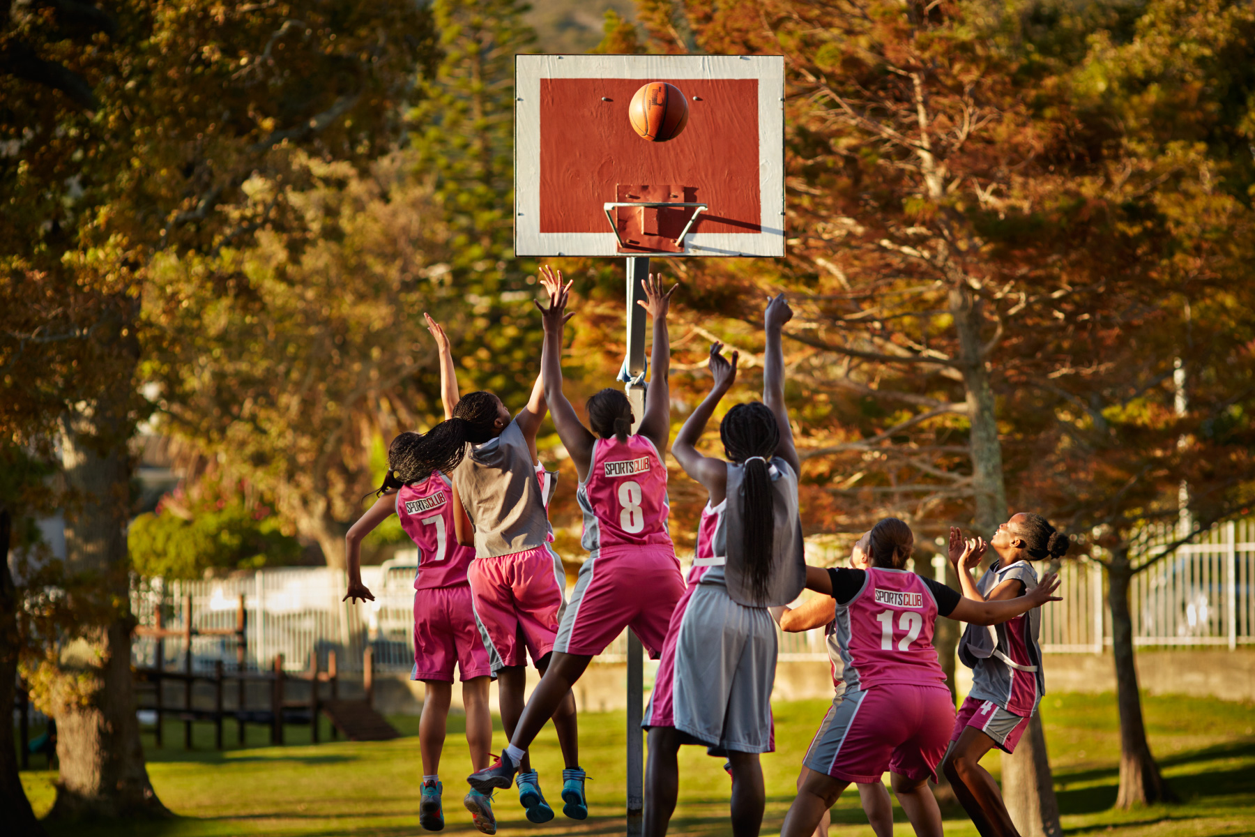 Female amateur basket team scoring goal at practice