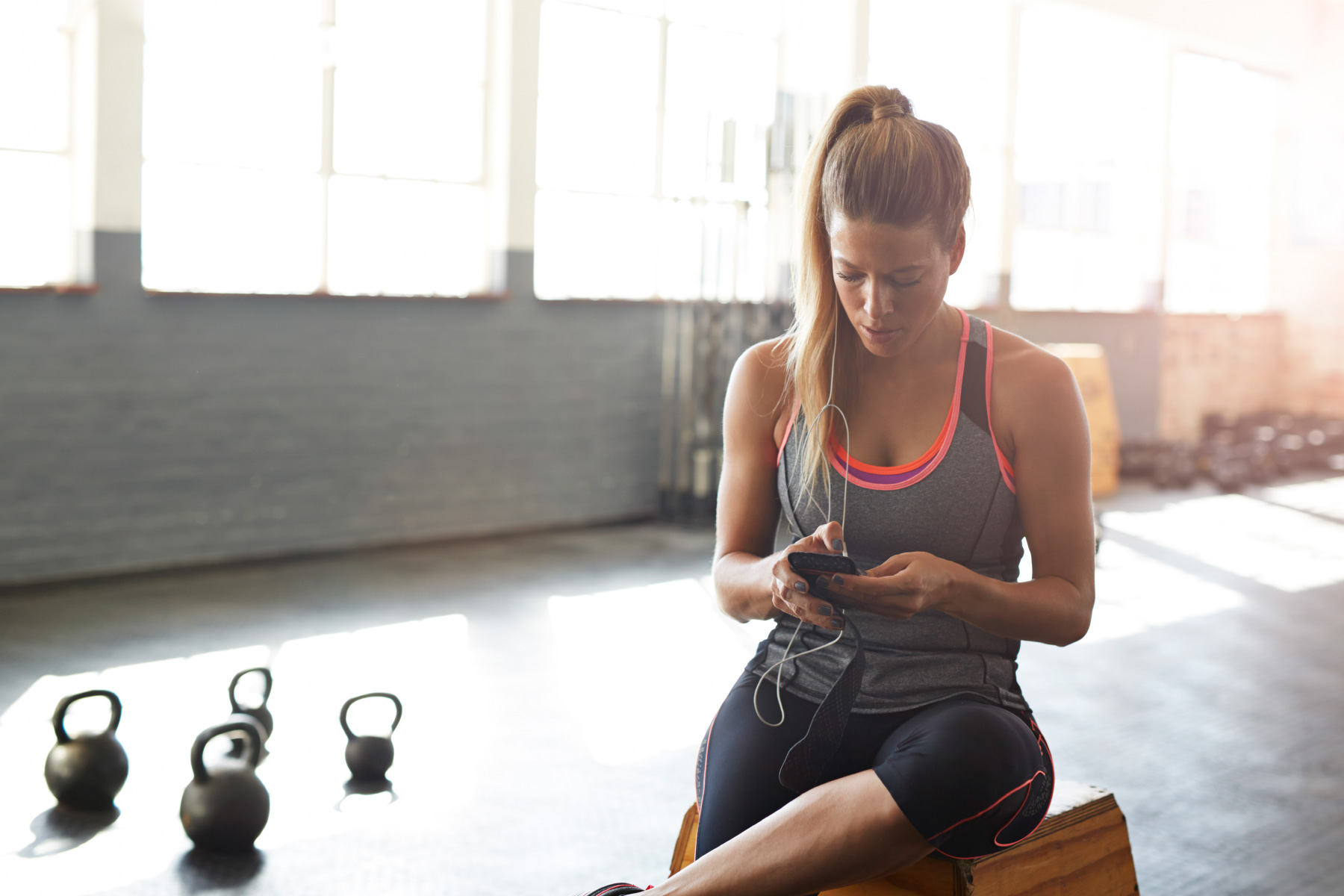 Woman checking smartphone in gym 