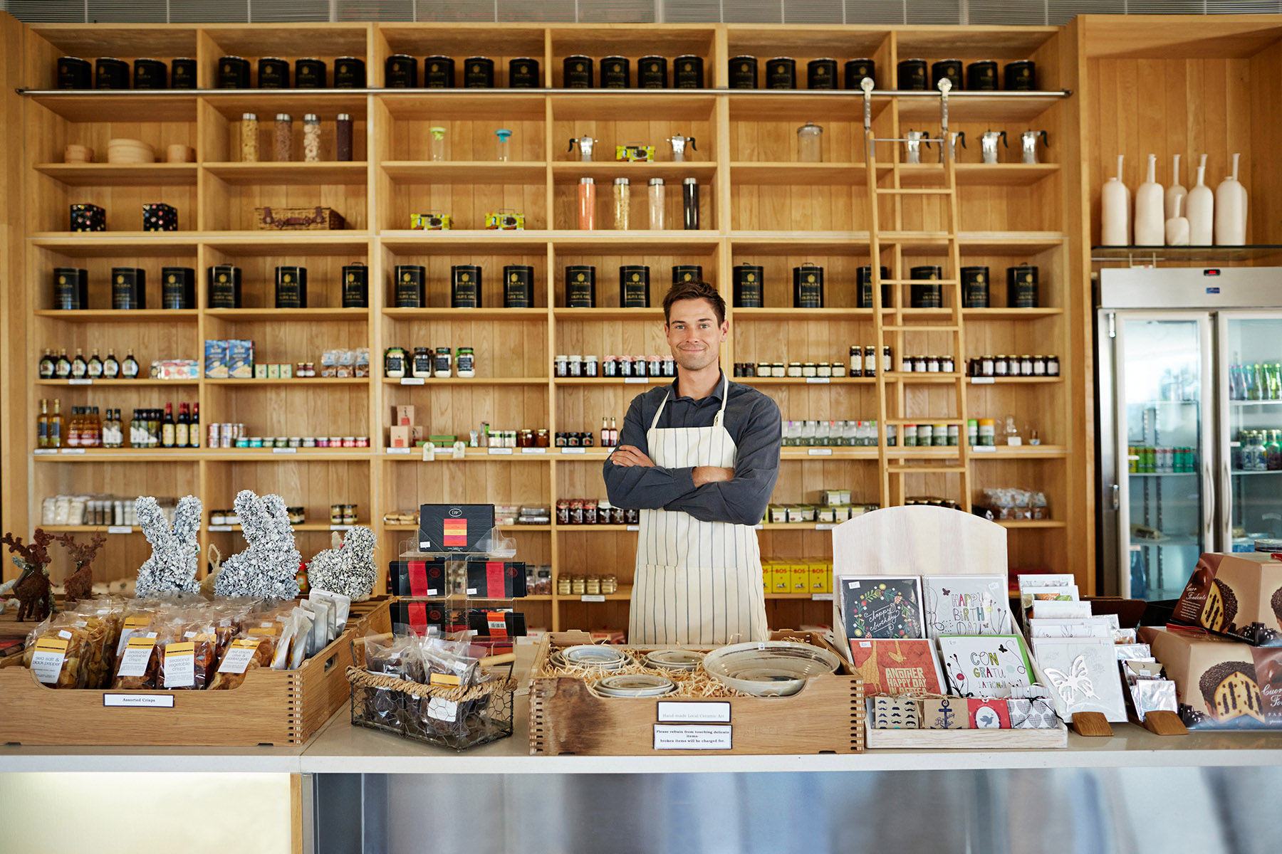Deli shop owner standing behind counter